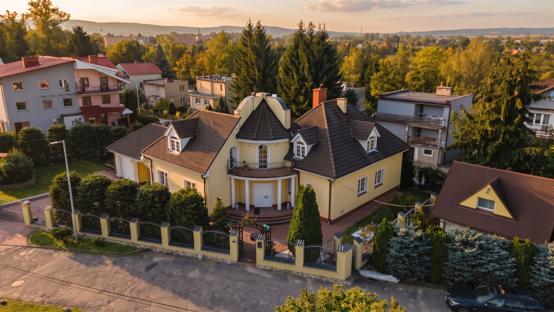 Front domu z lotu ptaka, widoczna wieżyczka i garaż w bryle